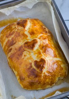 a loaf of bread sitting on top of a piece of wax paper in a pan