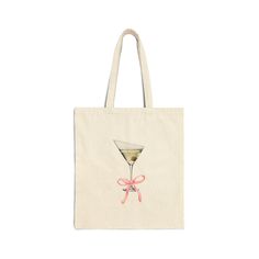 a tote bag with an image of a martini glass and pink ribbon on it