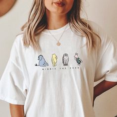 a woman wearing a white t - shirt with three cartoon animals on it's chest