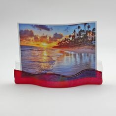 a greeting card with an image of a sunset on the beach and palm trees in the background