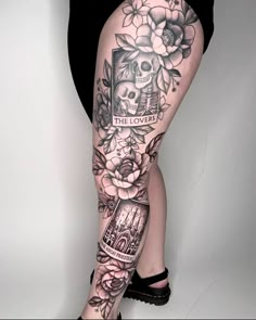 a woman's leg with tattoos and flowers on it