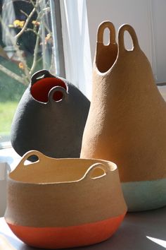 three pots sitting on top of a table next to a window