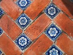 an orange and blue tiled floor with white flowers