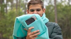 a young man is holding a towel and cell phone