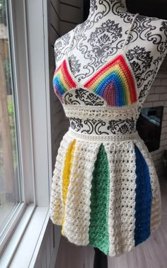 a crocheted dress is displayed on a mannequin in front of a window