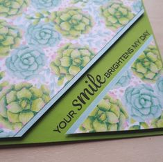 a close up of a greeting card with flowers on the front and green trimming