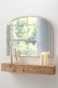 a mirror and some candles on a shelf