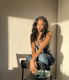 a woman sitting on top of a chair next to a wall