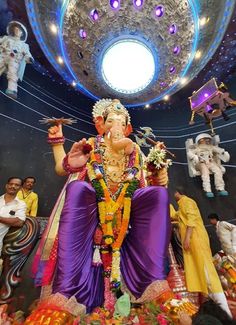 the statue of lord ganesh is surrounded by other people