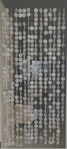 a glass window with white circles hanging from it