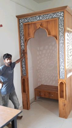 a man standing in front of a wooden room divider