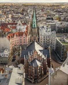 an aerial view of a city with tall buildings and steeple spires in the background