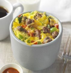 two cups filled with food sitting on top of a table next to a fork and knife