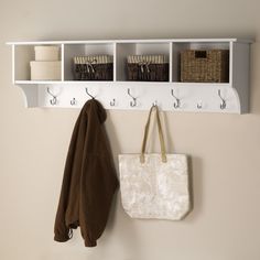 a white coat rack with two coats hanging from it's sides and three baskets on the wall