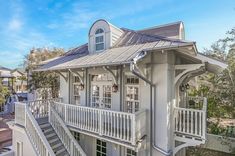 a white house with a metal roof and balcony