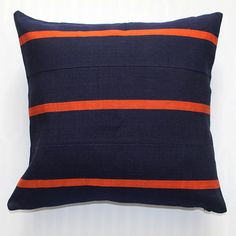 a blue and orange striped pillow on a white background with an orange stripe down the middle