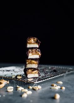 three pieces of cake sitting on top of a cooling rack next to nuts and seeds