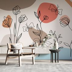 a living room with flowers painted on the wall and two chairs in front of it