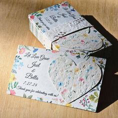 two wedding envelopes sitting on top of a wooden table