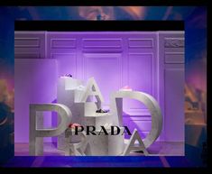 an advertisement for prada is displayed in front of a purple wall with the words prada on it