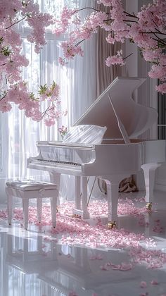 a white piano sitting in front of a window with pink flowers on the floor next to it