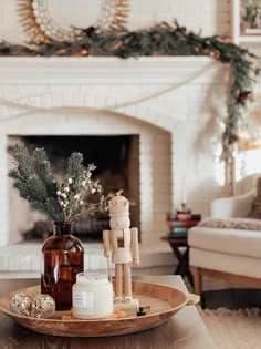 a living room filled with furniture and a fire place covered in christmas decorations on top of a wooden tray