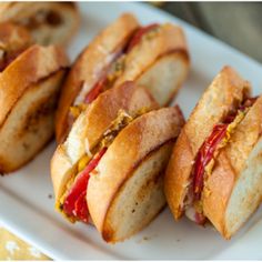 several sandwiches are arranged on a white plate