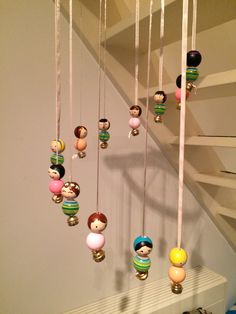 a bunch of beads hanging from a string on a wall next to a stair case