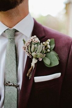 a man wearing a suit and tie with a boutonniere on his lapel