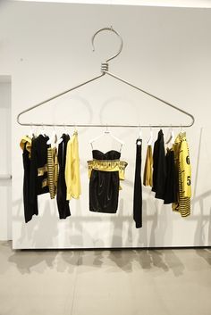 clothes are hanging on a rack in an empty room with white walls and flooring