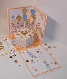 a birthday card with balloons and confetti on it, sitting next to other greeting cards