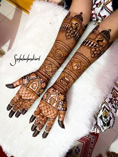 two hands with henna designs on them