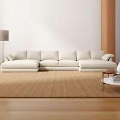 a white couch sitting on top of a hard wood floor next to a coffee table