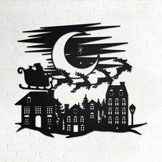 a metal wall art depicting santa's sleigh flying over the city at night