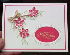 a hand holding up a birthday card with flowers on the front and back side,