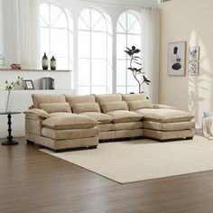 a living room with a large sectional couch in the center and a rug on the floor