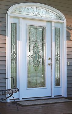 the front door is decorated with glass and has a bench on the side walk way