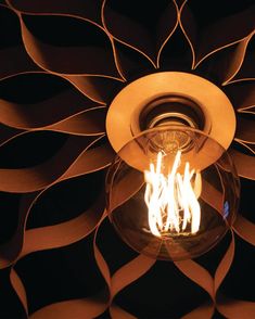 a light bulb is lit in the middle of a decorative wallpapered room with flames coming out of it