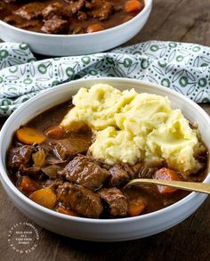 two bowls filled with beef stew and mashed potatoes