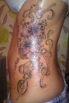 a woman's lower back tattoo with flowers on it