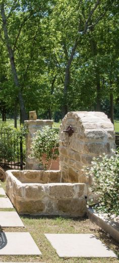 a bike is parked in front of a stone wall and planter on the sidewalk