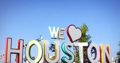 we love houston sign with trees in the background