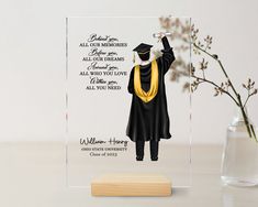 a clear acrylic plaque with a graduation cap and gown on it's front