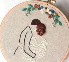 a close up of a embroidery on a hoop with a woman's face and hair