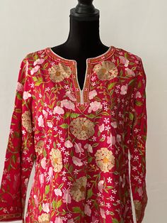 Made with finest silk fabric and embroidered using vintage craftsmanship, makes this a customer favorite for it's softness and unique style. Great for work, cover up. Must have from spring to fall.  Size Guide: SIZE: M (Length: 30 inches, Bust:40 Inches, Sleeves: 16 Inches) SIZE: L (Length: 30 inches, Bust:42 Inches, Sleeves: 16 Inches) SIZE: XL (Length: 30 inches, Bust:44 Inches, Sleeves: 16 Inches) SIZE: XXL (Length: 30 inches, Bust:46 Inches, Sleeves: 16 Inches) CARE: Dry Clean Only Spring Silk Kurta With Embroidered Neckline, Red Silk Long Sleeve Kurta, Red Silk Kurta For Spring, Red Tunic Kurta With Resham Embroidery, Spring Silk Tops With Resham Embroidery, Traditional Silk Tunic For Spring, Silk Tops With Resham Embroidery For Spring, Red Kurta For Spring, Silk V-neck Top With Embroidery