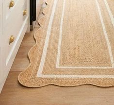 a beige rug is on the floor next to a white cabinet and drawers in a kitchen