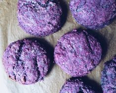 purple cookies sitting on top of a piece of wax paper