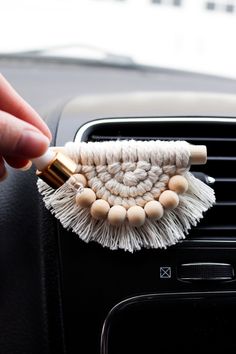 a person is holding a brush in the air freshener dispenser on a car dashboard