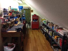 a room filled with lots of clutter next to a wooden floor and shelves full of items