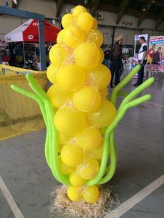 a bunch of balloons that are in the shape of a tree on some hay and straw